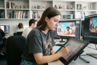 Jeune femme en train de dessiner un personnage 3D sur tablette